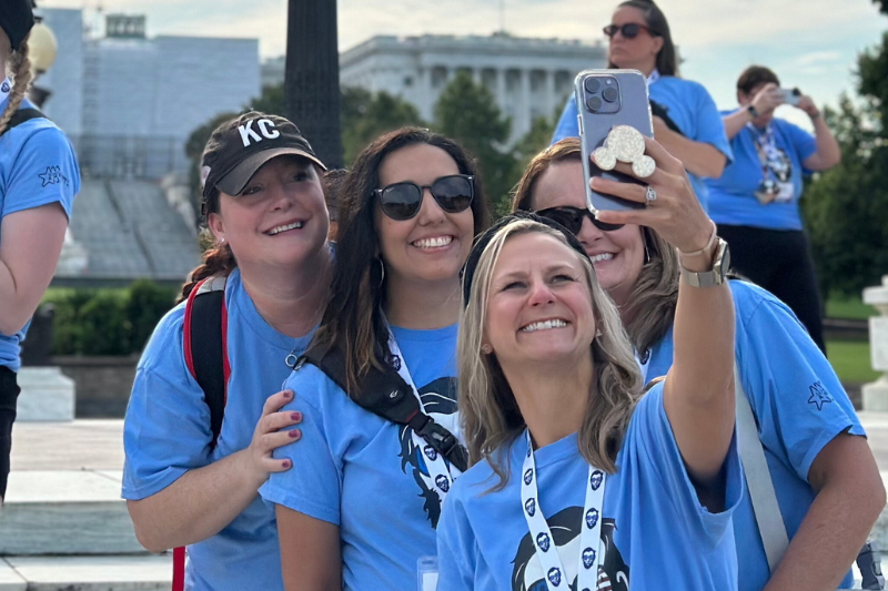 A group of teachers take a selfie in front of the US Capitol.