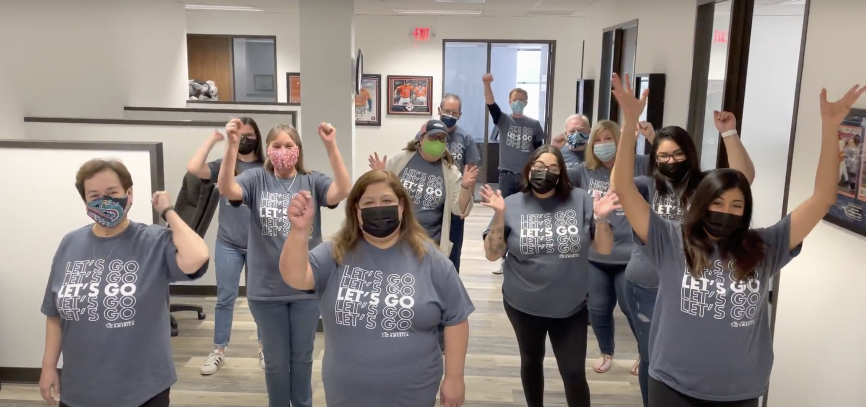 STA's Houston team gathers in unison with COVID masks on and Let's Go tshirts.